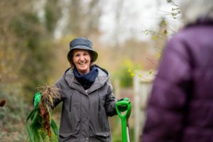 A person smiling whilst gardening.