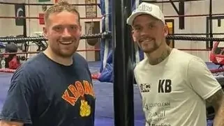 Tobie and his trainer poe outside a boxing ring, celebrating his journey to better physical and mental health.